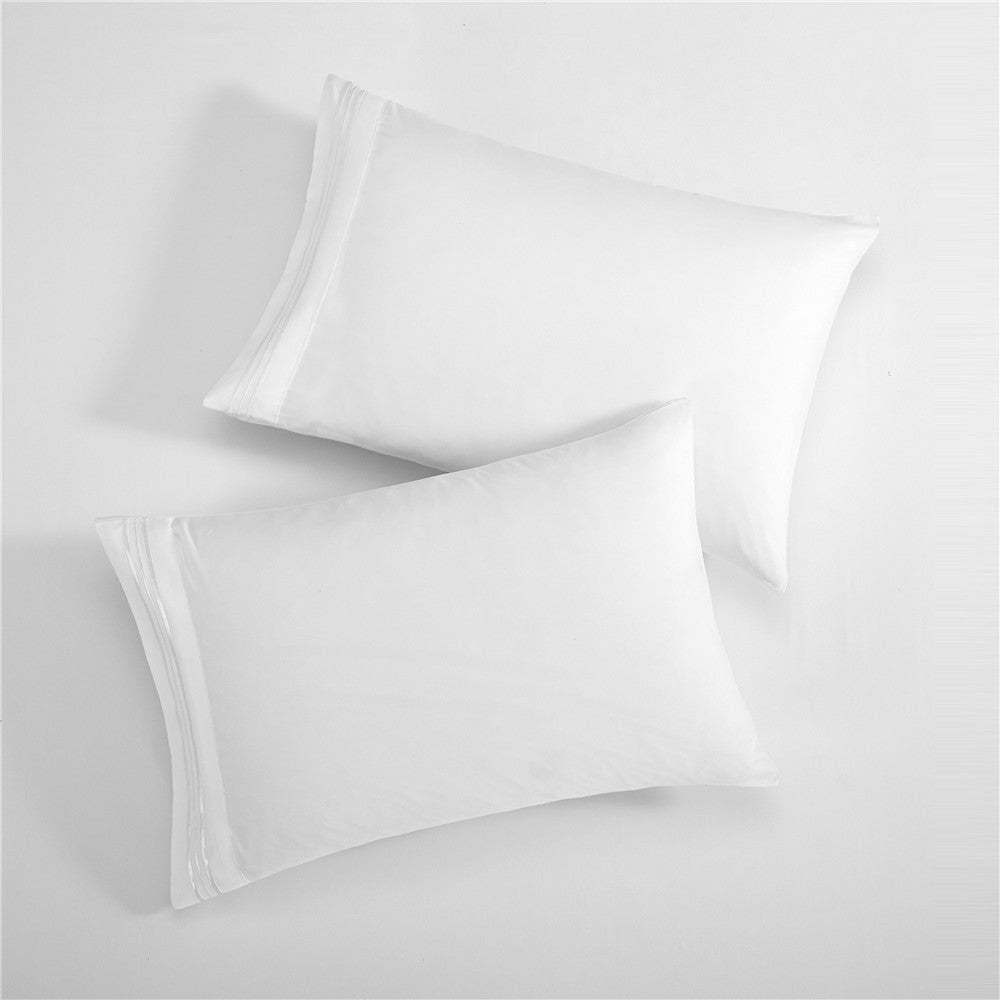 Two white pillows with embroidered design on a white background